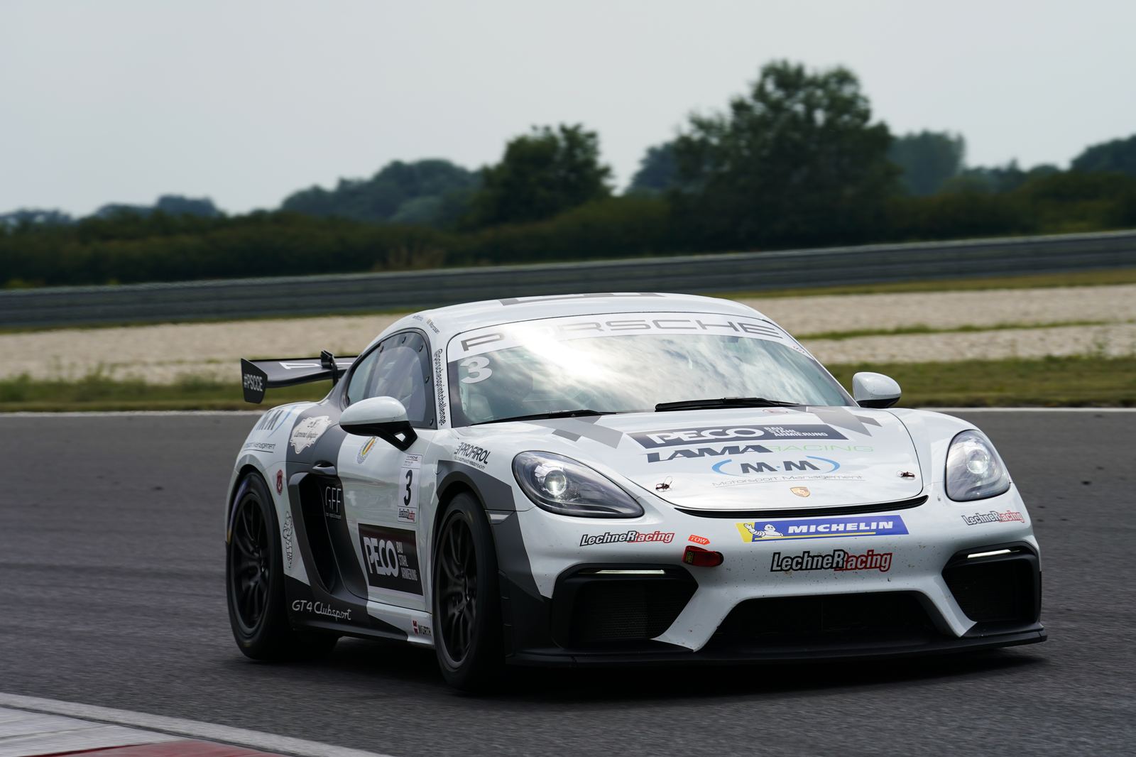 Rennwagen mit M·M Logo auf der Motorhaube